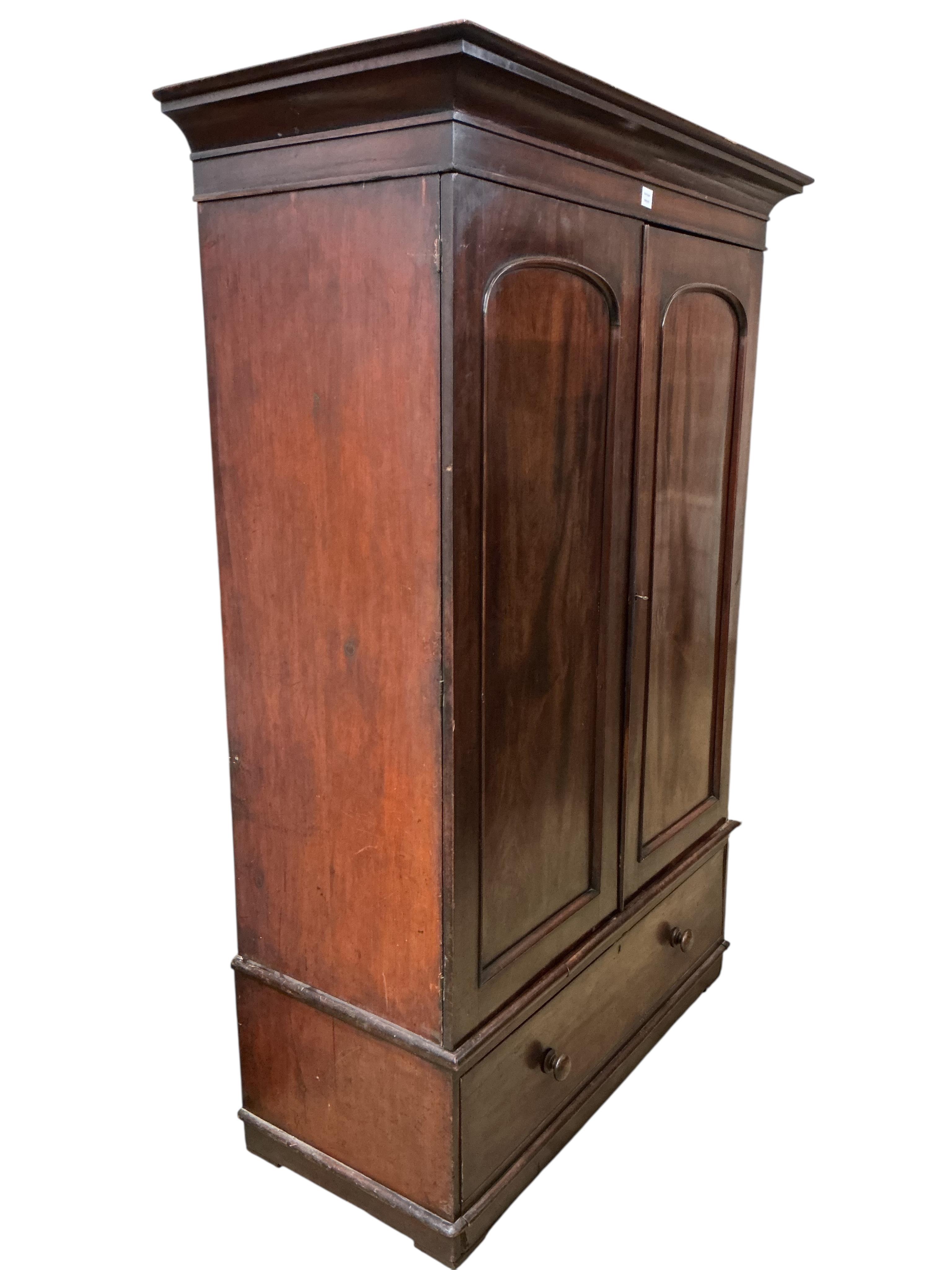 A Victorian mahogany two door wardrobe, fitted with a base drawer, width 140cm, depth 63cm, height 206cm